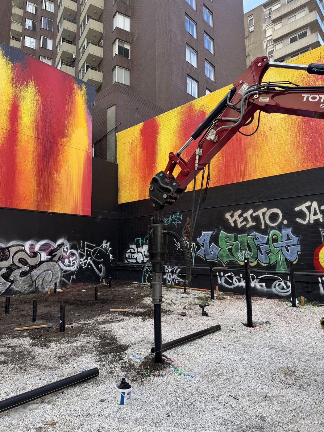 Total Piling excavator screwing piles at an inner-Melbourne CBD site