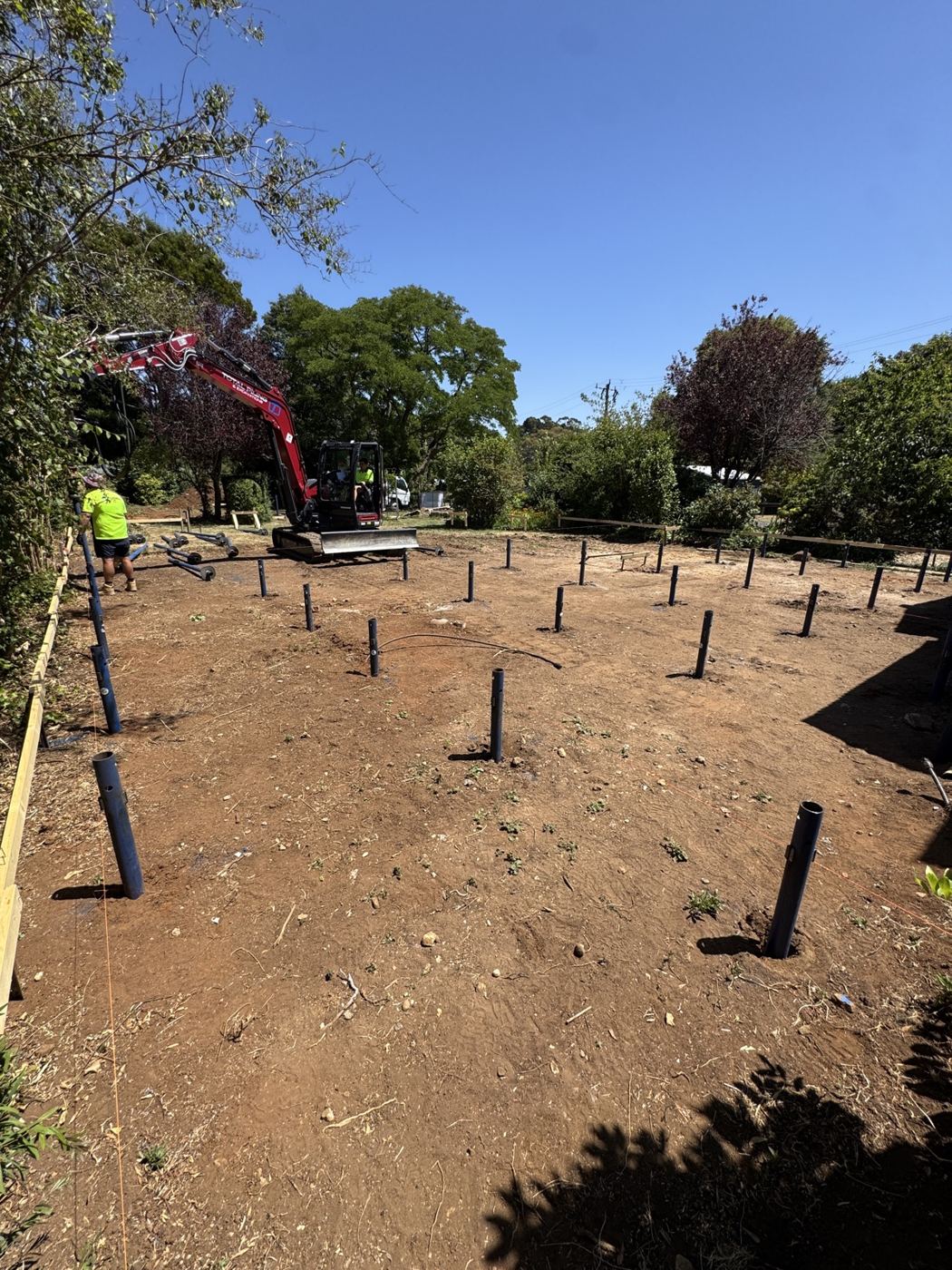 Engineered grid of screw piles installed across a rural Victorian pad