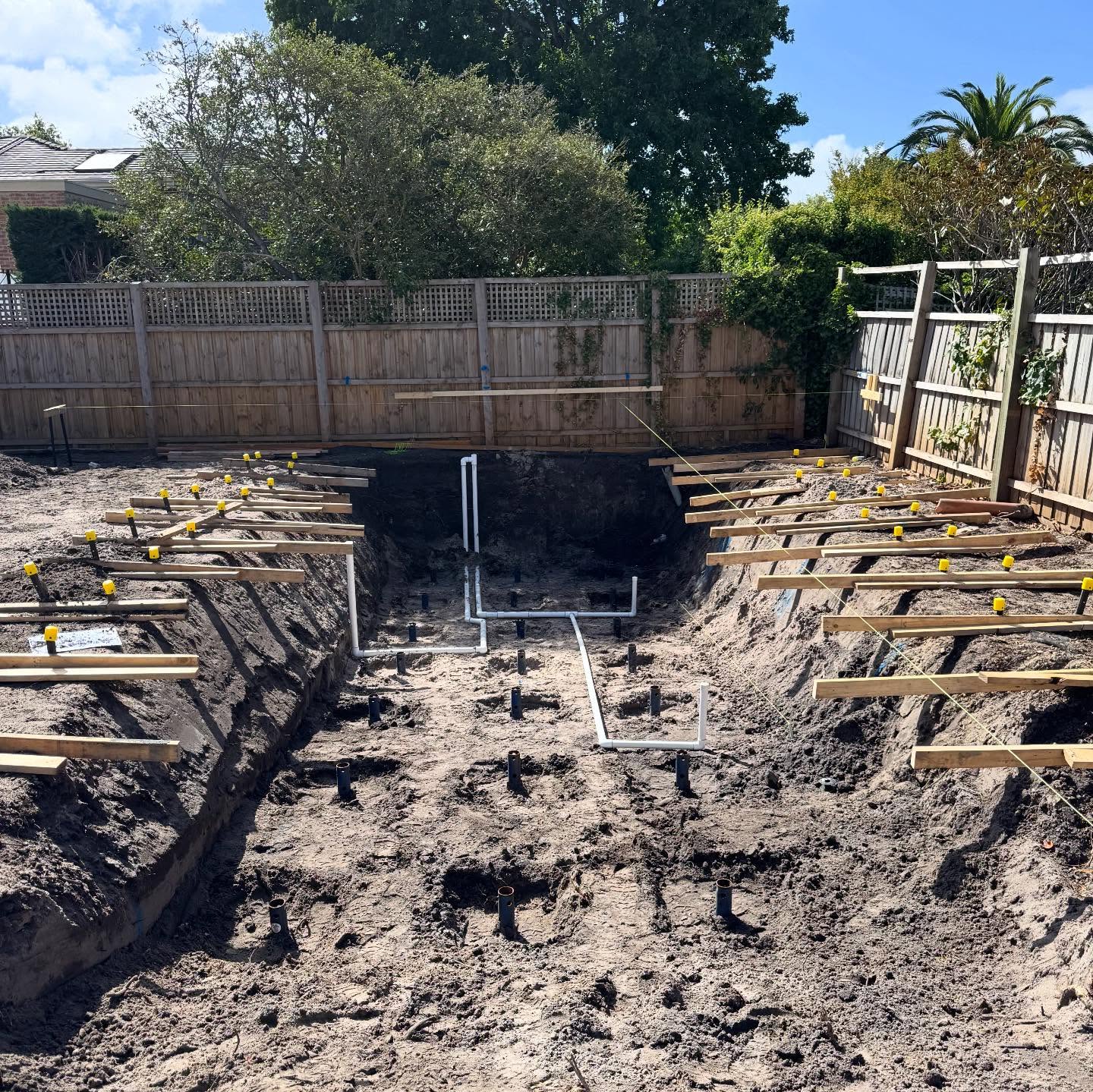 Pool excavation pit with screw piles installed around the perimeter